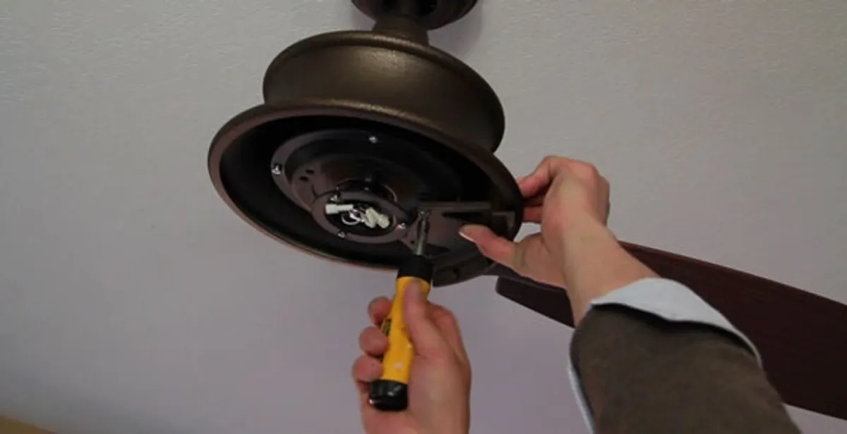 Electrician installing ceiling fan mounting bracket and fixture in Staten Island, NY