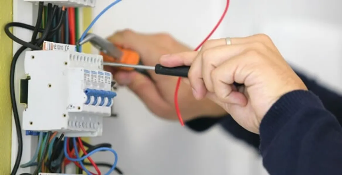 Electrician installing and adjusting circuit breakers in an electrical panel in Staten Island, NY