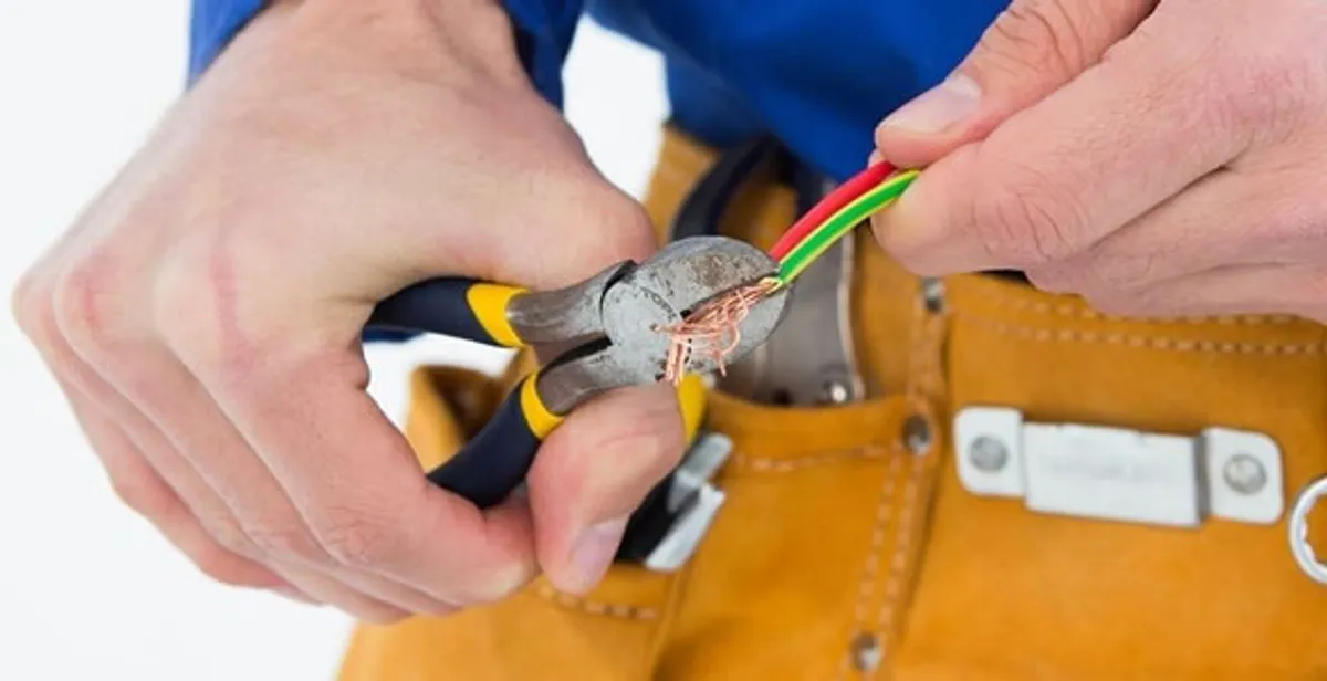 licensed electrician securing electrical wiring with professional tools during service work in Staten Island, NY
