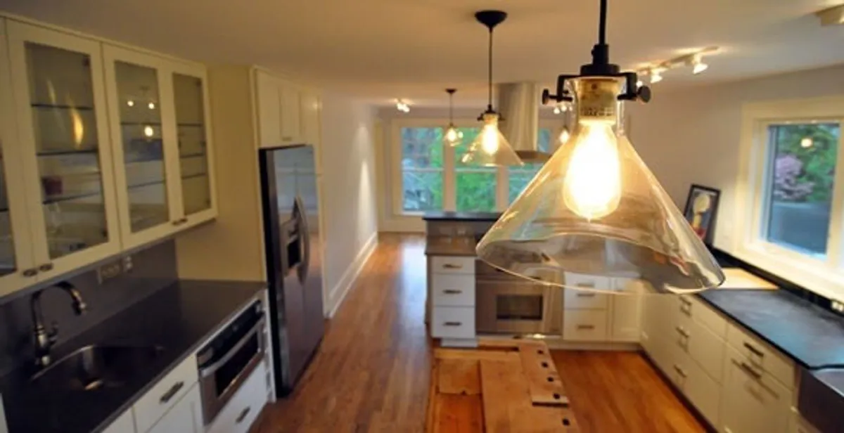 Residential electrician installing modern indoor light fixture in a home in Staten Island, NY