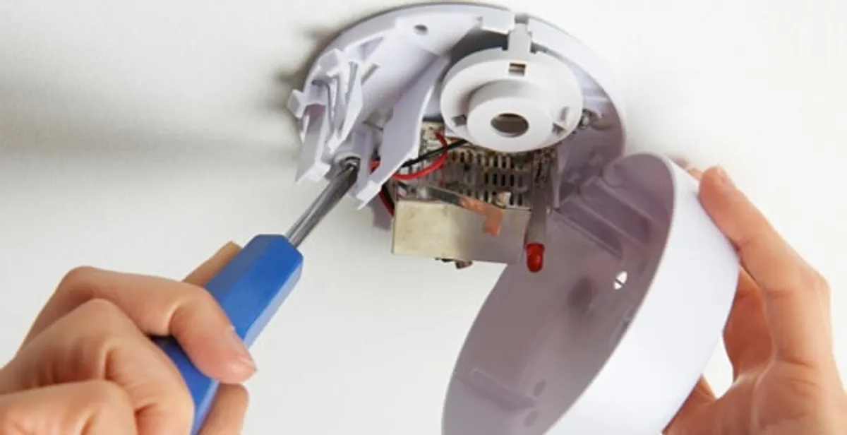 Certified technician wiring smoke detector during installation in Staten Island, NY